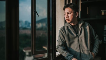 Mental Health: Men's Health: pensive man looking out the window 1219351014