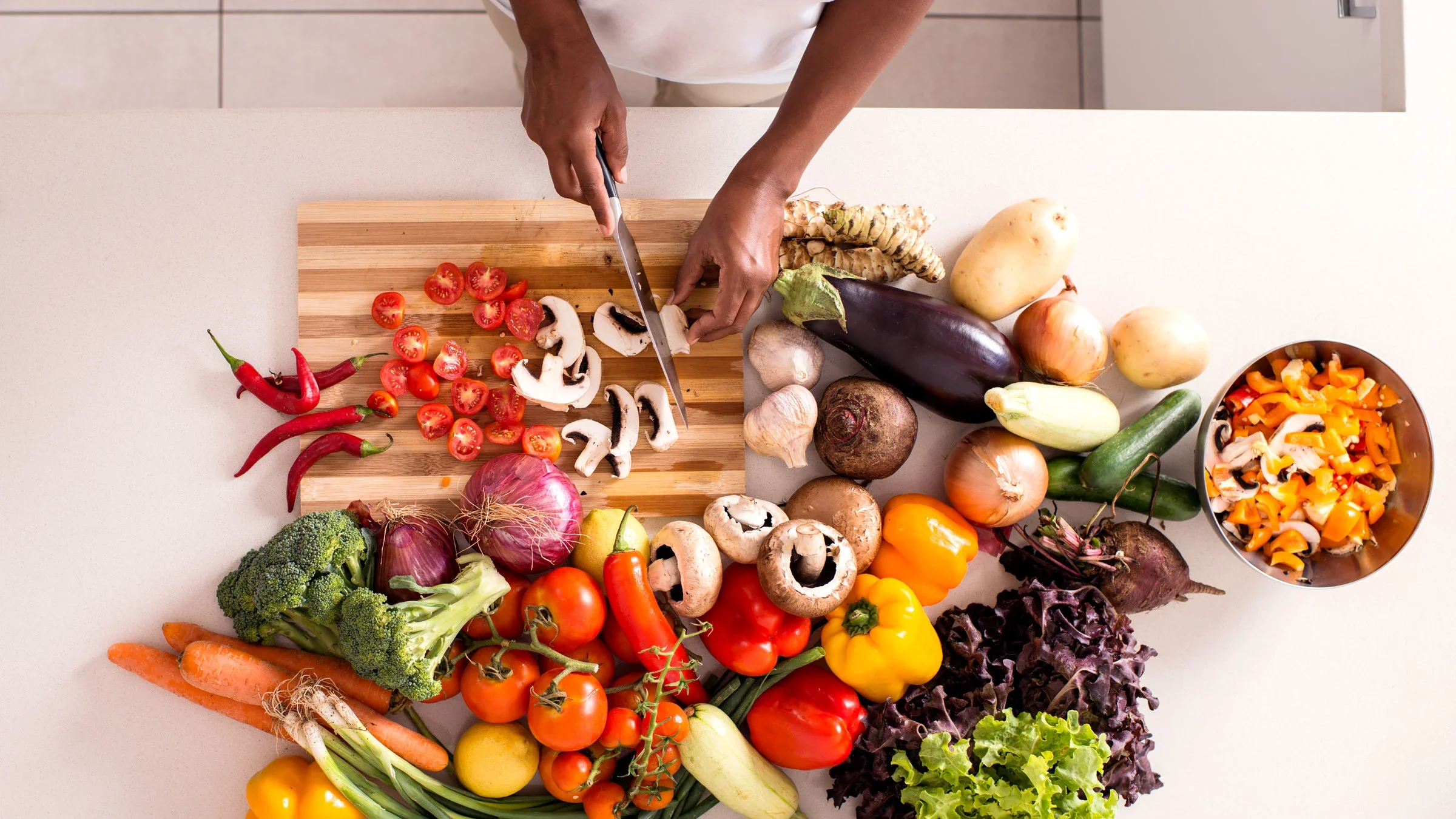 Overhead shot of woman preparing assortment of vegetables.
RuslanDashinsky/E+ via Getty Images 