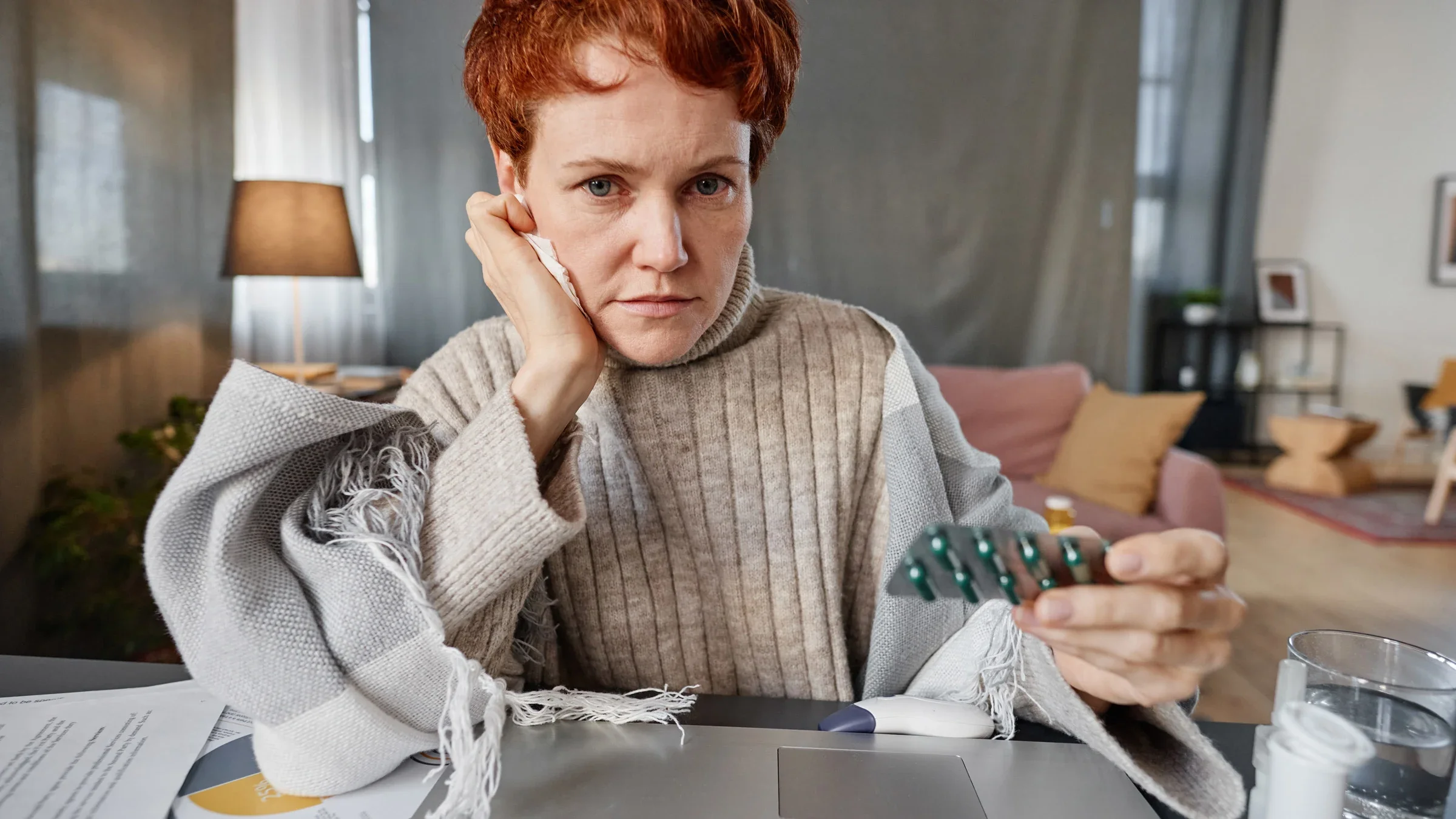 Senior woman holding a blister pack in a telehealth call.
mediaphotos/iStock via Getty Images Plus 