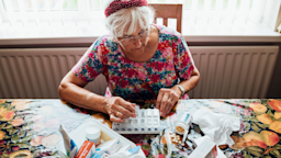 Senior woman sorts through pillbox.
SolStock/E+ via Getty Images