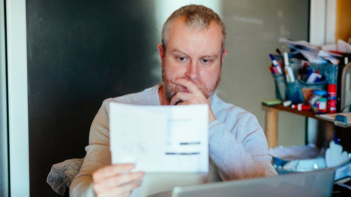 A man reads a medical bill.