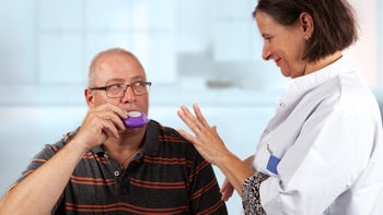 Asthma: man using an inhaler 1124707683