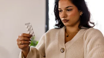 glp-1-agonists: woman holding blister pack of pills 1493625378