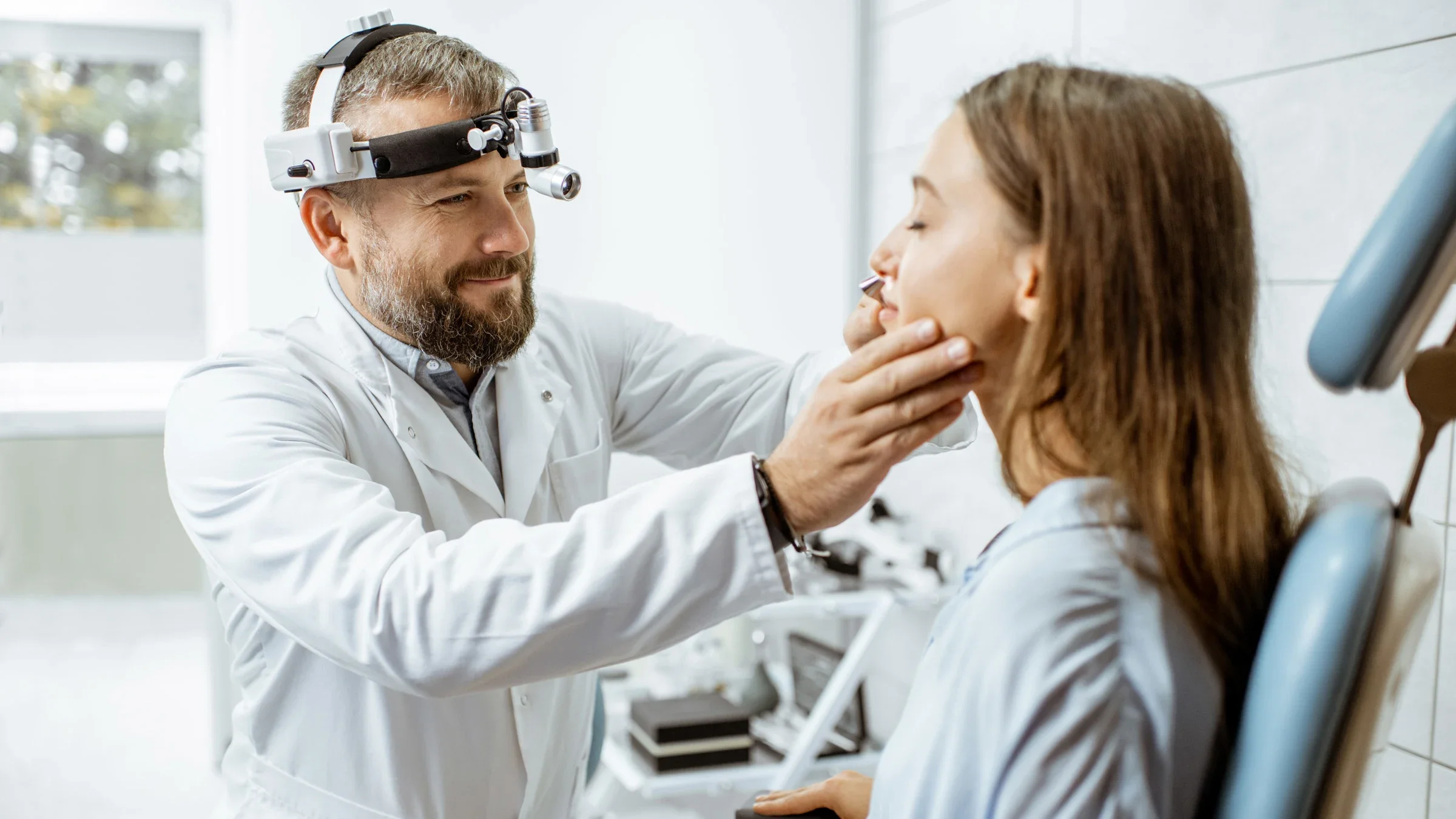 A doctor examining their patient's nose.
RossHelen/iStock via Getty Images
