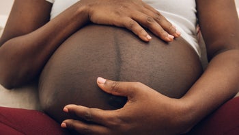 Health: Patient advocacy: closeup Black pregnant person holding belly-1377462955