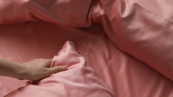 dermatology: closeup hand with silk pillowcase 1423015574