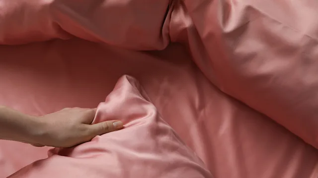 dermatology: closeup hand with silk pillowcase 1423015574