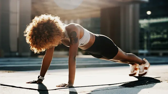 Movement exercise: Push-ups: fit woman holding plank-pose 1194421817