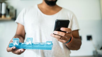 Health: Tramadol: man with pillbox and mobile phone 1167004307