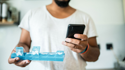 Man with pillbox and smart phone.
kovaciclea/iStock via Getty Images Plus