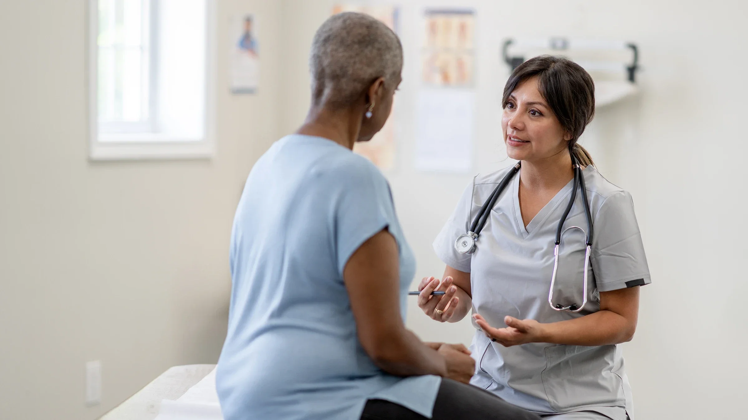 A medical professional talks with a woman during a health exam.  Treatment options for hidradenitis suppurativa, a chronic skin condition, include topical treatments, medication, and surgery.
FatCamera/E+ via Getty Images