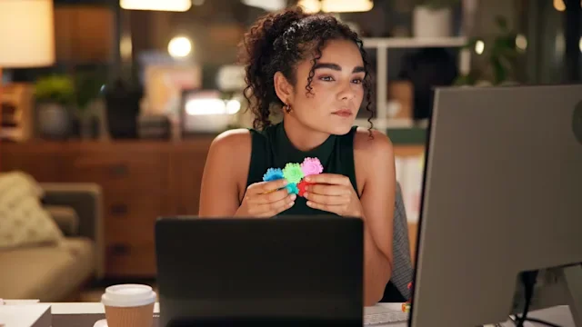 ADHD: woman using adhd toy at her desk 2197604060