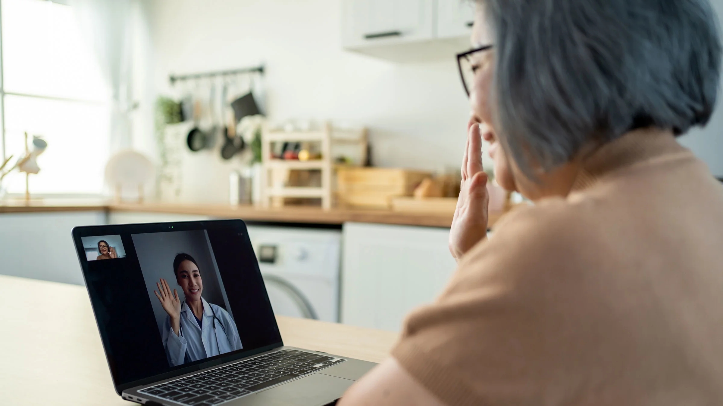 A woman talks with her doctor on a telehealth call.