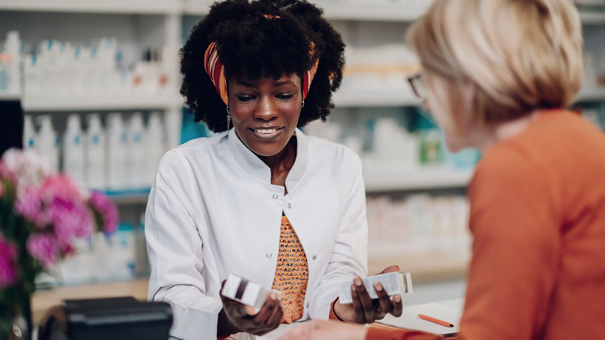 A pharmacist is explaining a medication to an older customer.