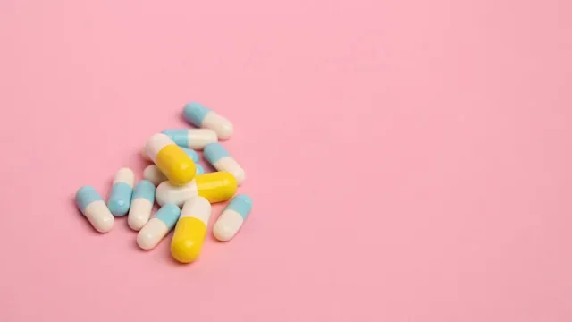 two color pills on pink background-909779234