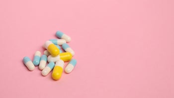 two color pills on pink background-909779234