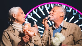 Behavioral addiction: Love older couple sharing cotton candy by ferris wheel-1286880143