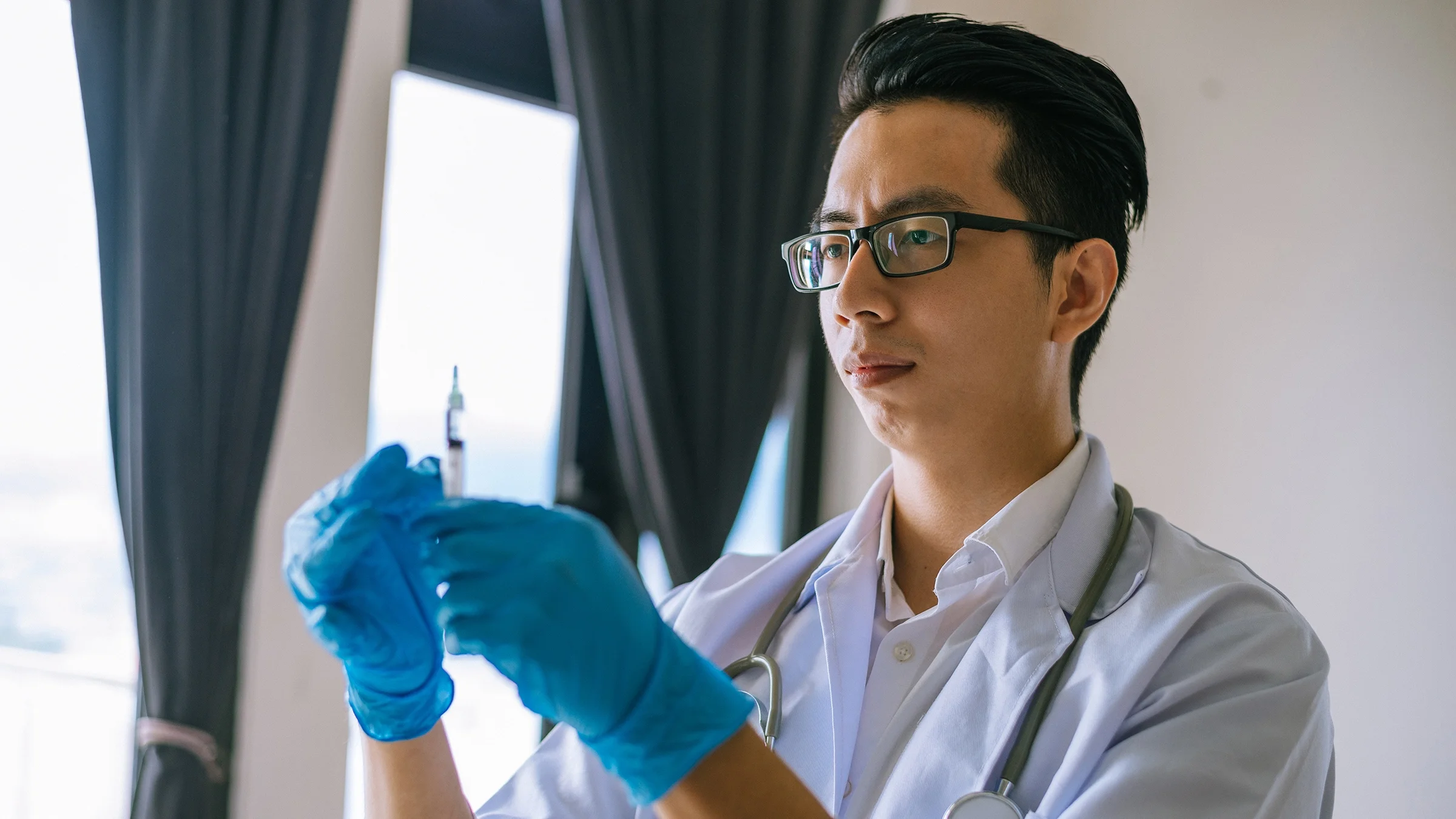 A healthcare professional is holding a syringe.
