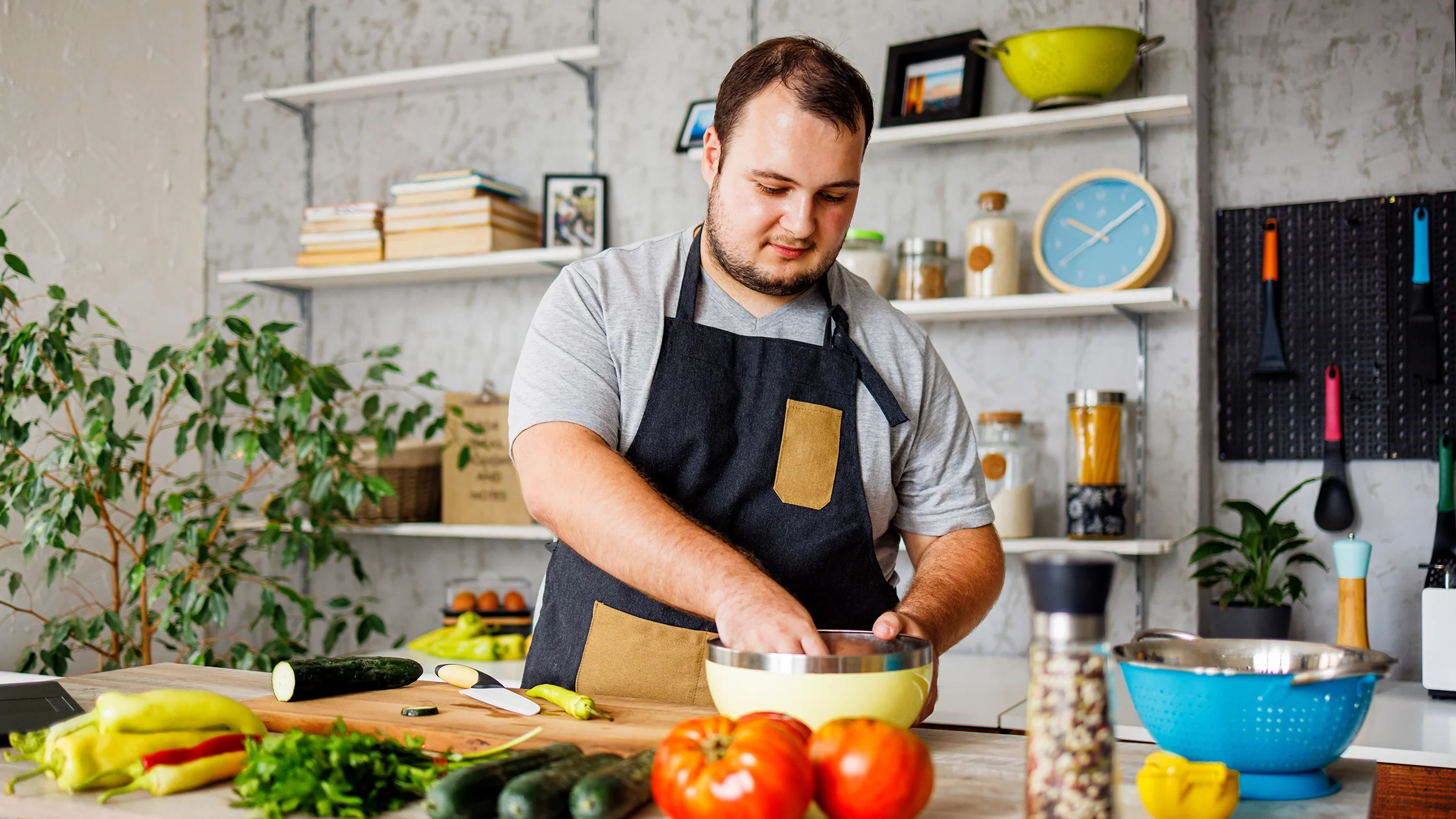 A man makes a salad in the kitchen. Increasing fiber intake can help against Mounjaro-related constipation.