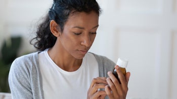 Health: Topiramate: woman reading Rx bottle 1307943290