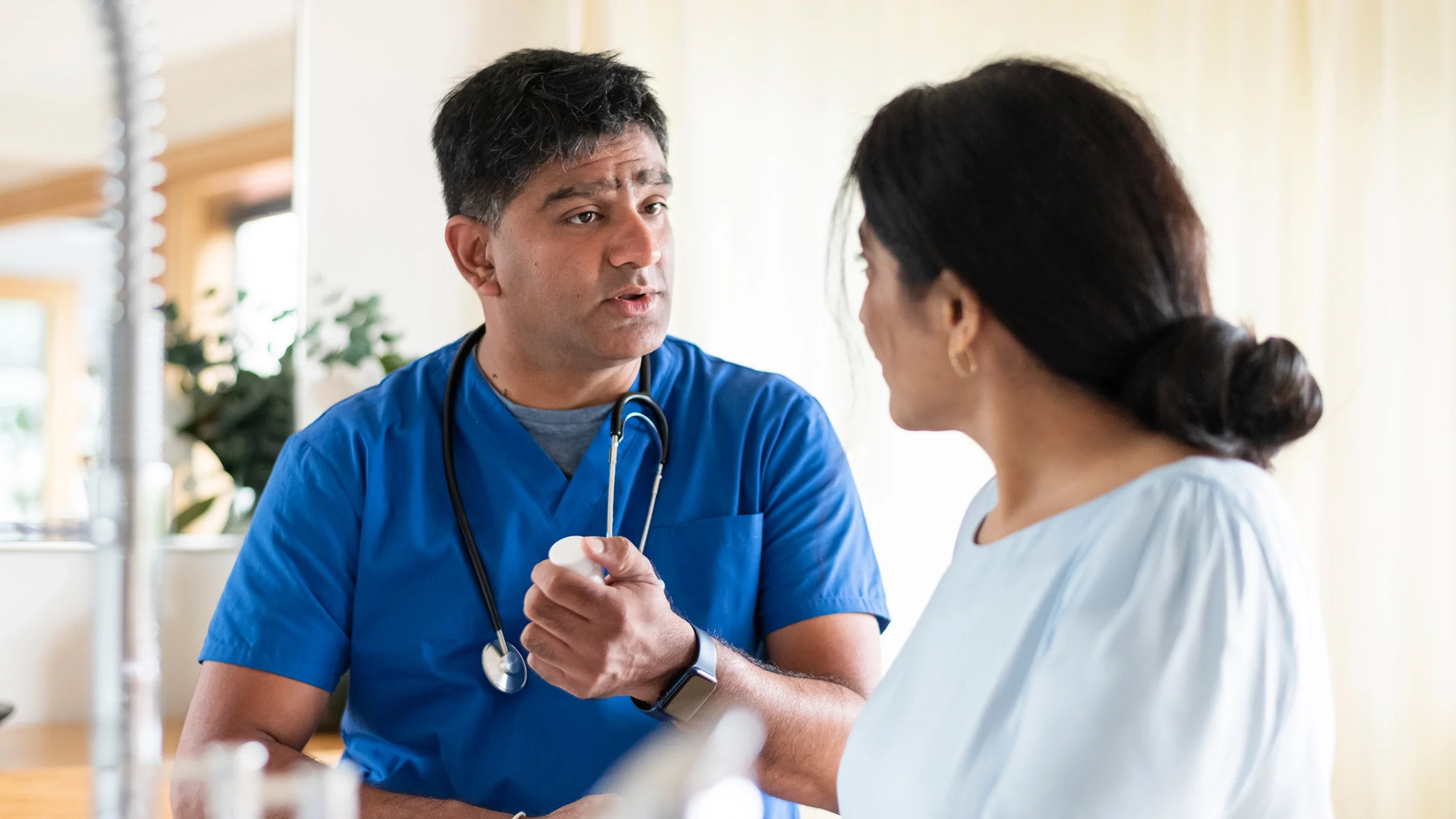 A medical professional talks with a patient about medication.