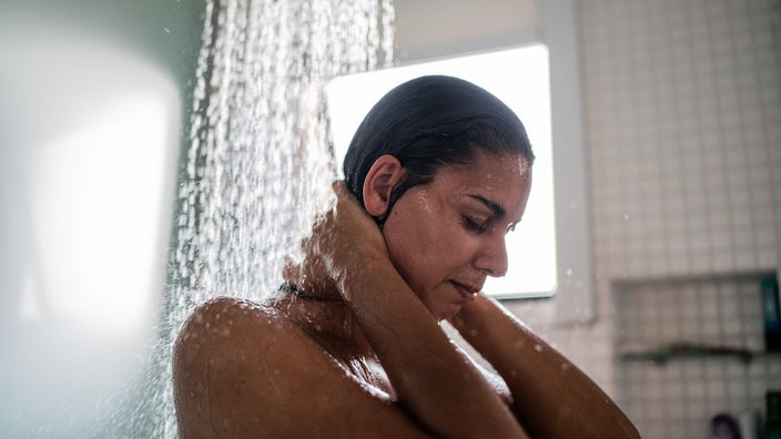 A woman takes a shower at home.