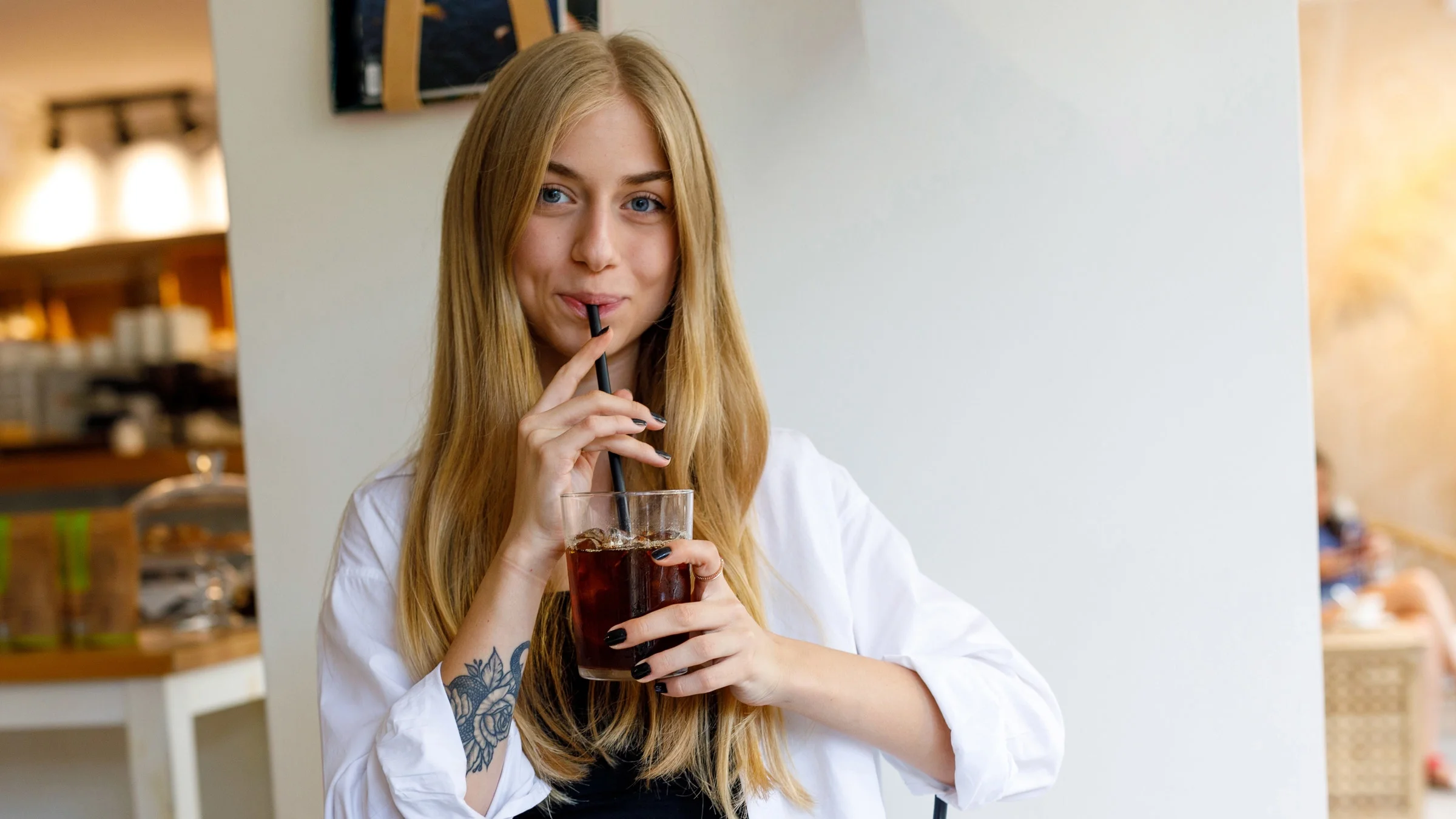 A person drinking coffee with a straw.