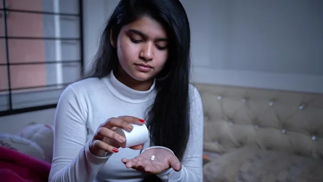 Pharmacy: woman taking medicine before bed 1312125594