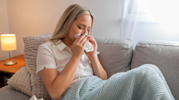 A sick woman sits under a blanket.
makyzz/iStock via Getty Images Plus