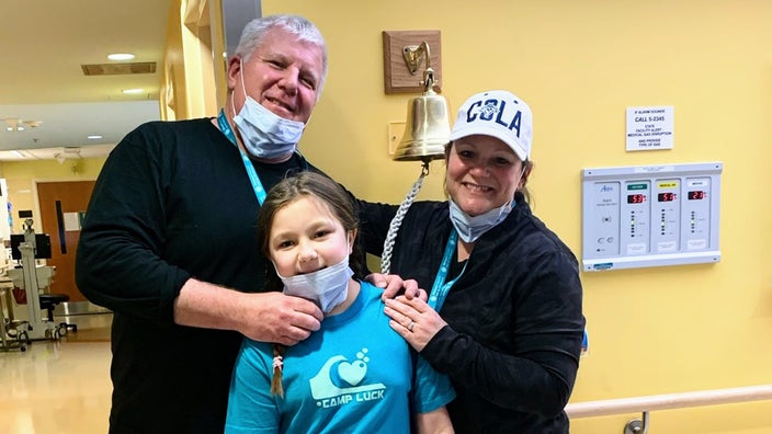 Joe and Renee Brownlee are pictured with their daughter Sophia in a hospital hallway.