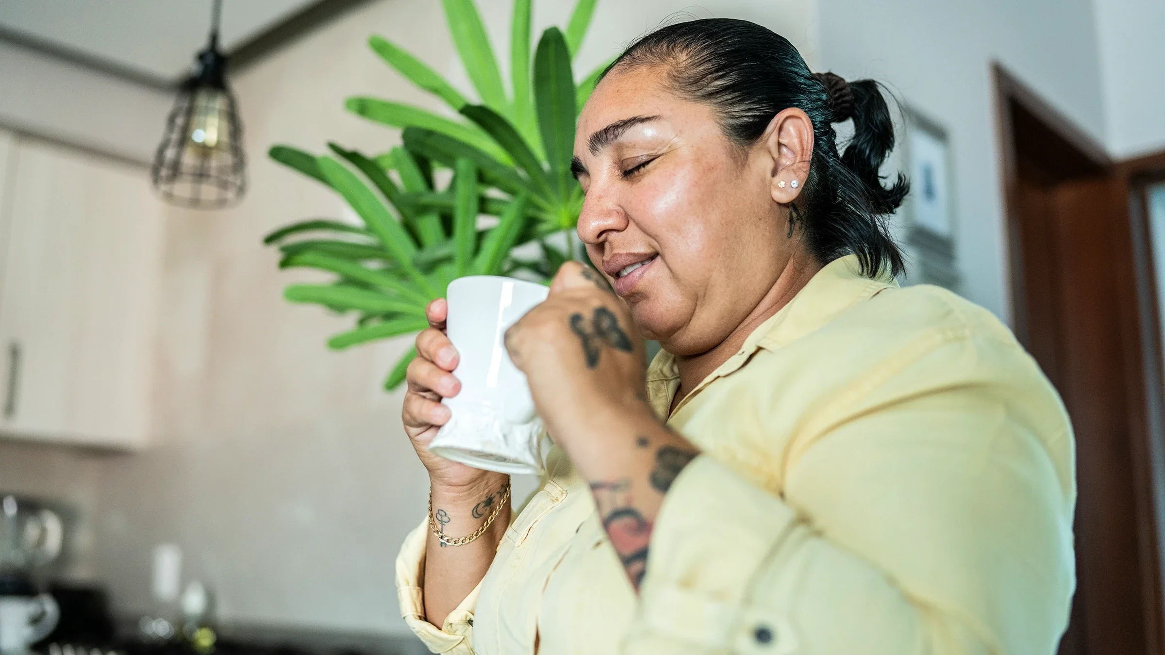 Woman drinking out of a white mug.