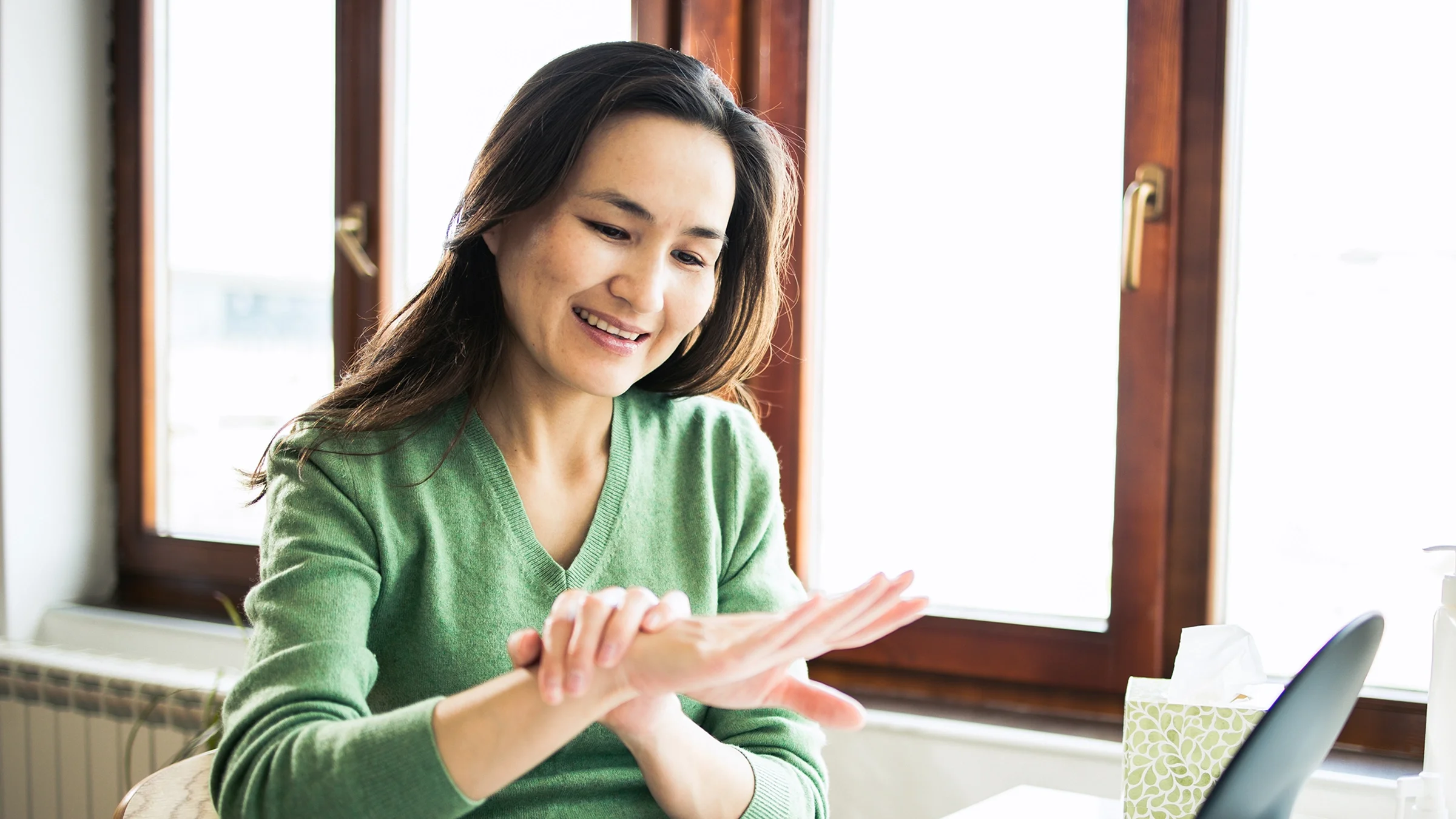 A woman is looking at her hand.