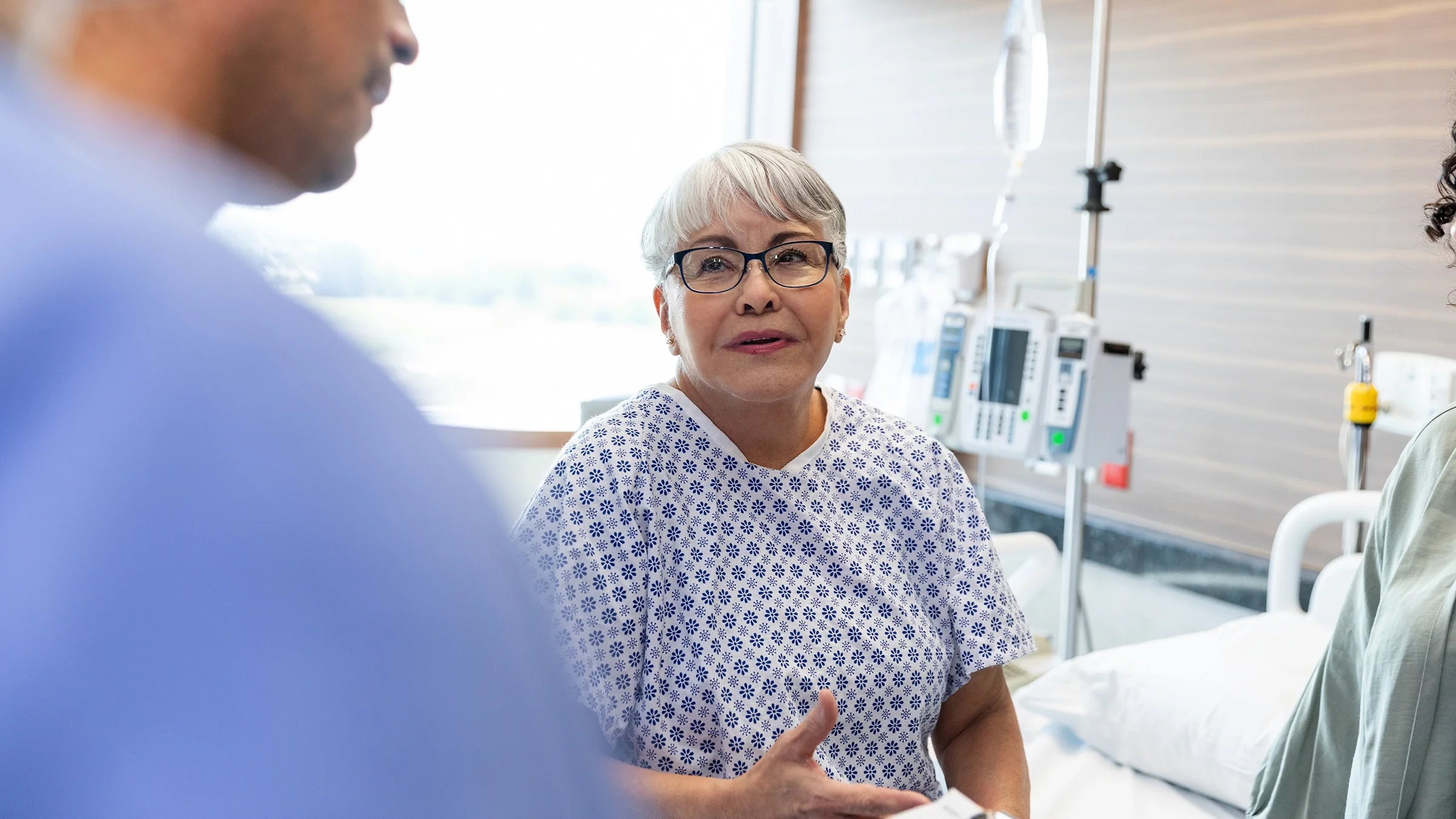 Healthcare professionals explain a diagnosis to an older patient.