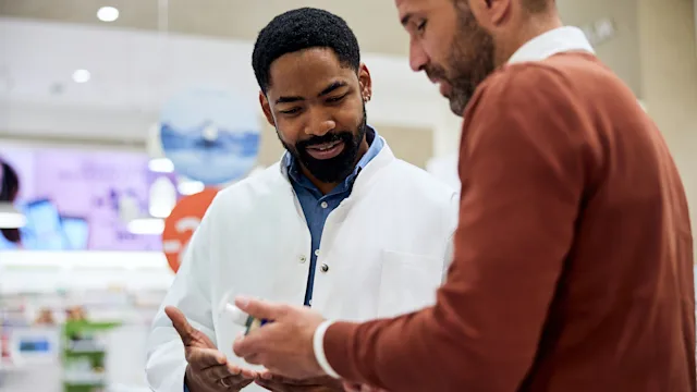 cimetidine: man speaking to pharmacist 2215299364