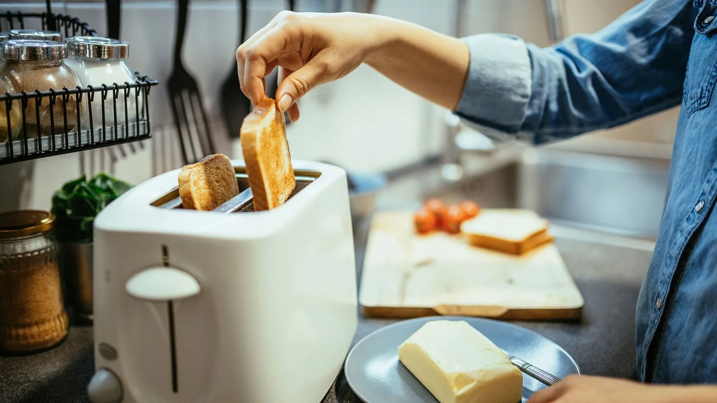 Close-up of a person reaching for the toast and taking it out of the toaster.
CocoSan/iStock via Getty Images
