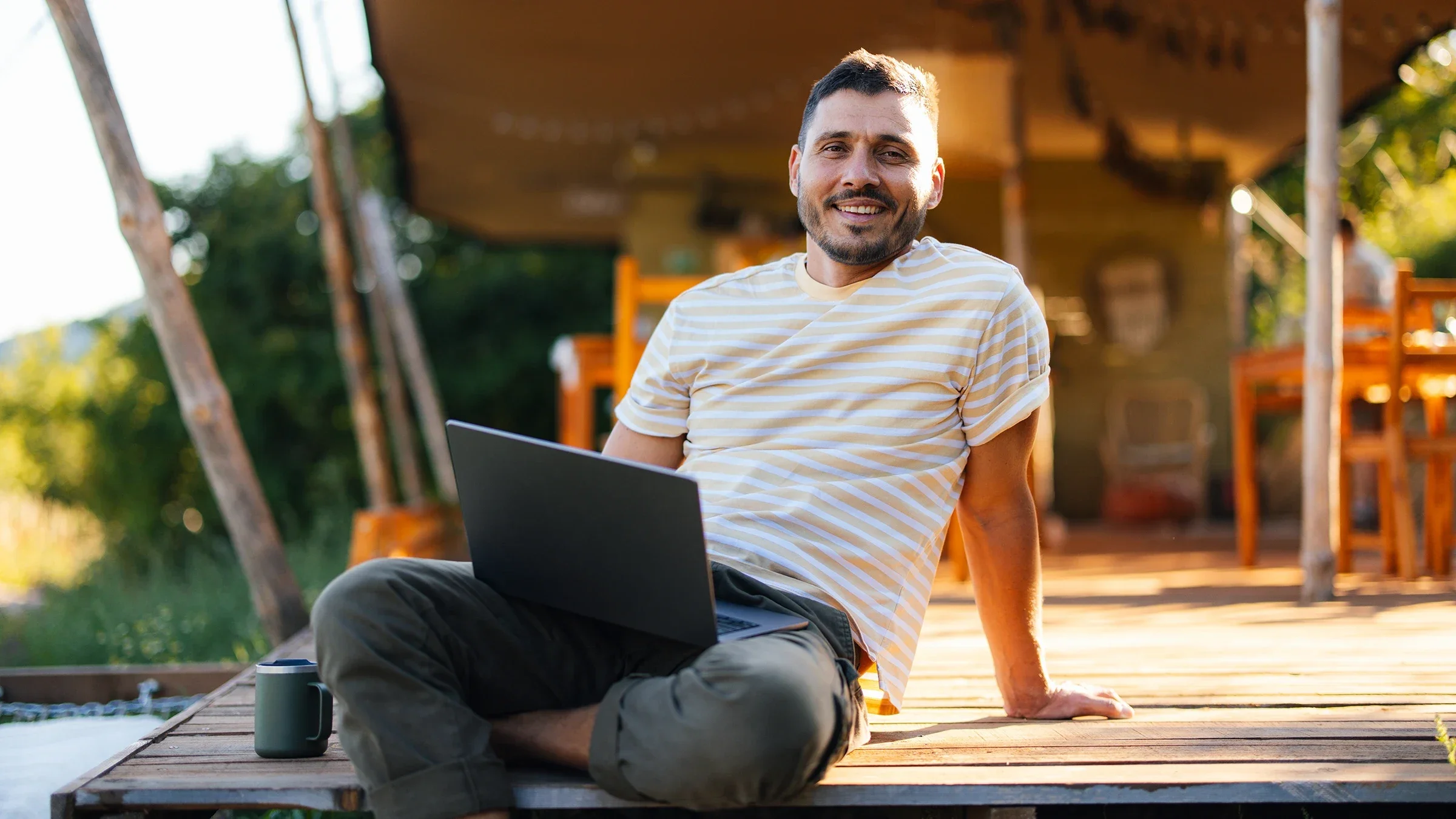 A man sits outdoors with a laptop.
miniseries/E+ via Getty Images