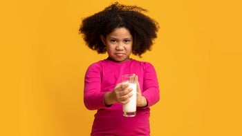 Health: Digestive: young girl discust face holding milk glass-1221347968