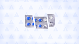 In the center of a blue background with texture and warning sign pattern is a blister pack of round blue pills cut into thirds.
GoodRx Health