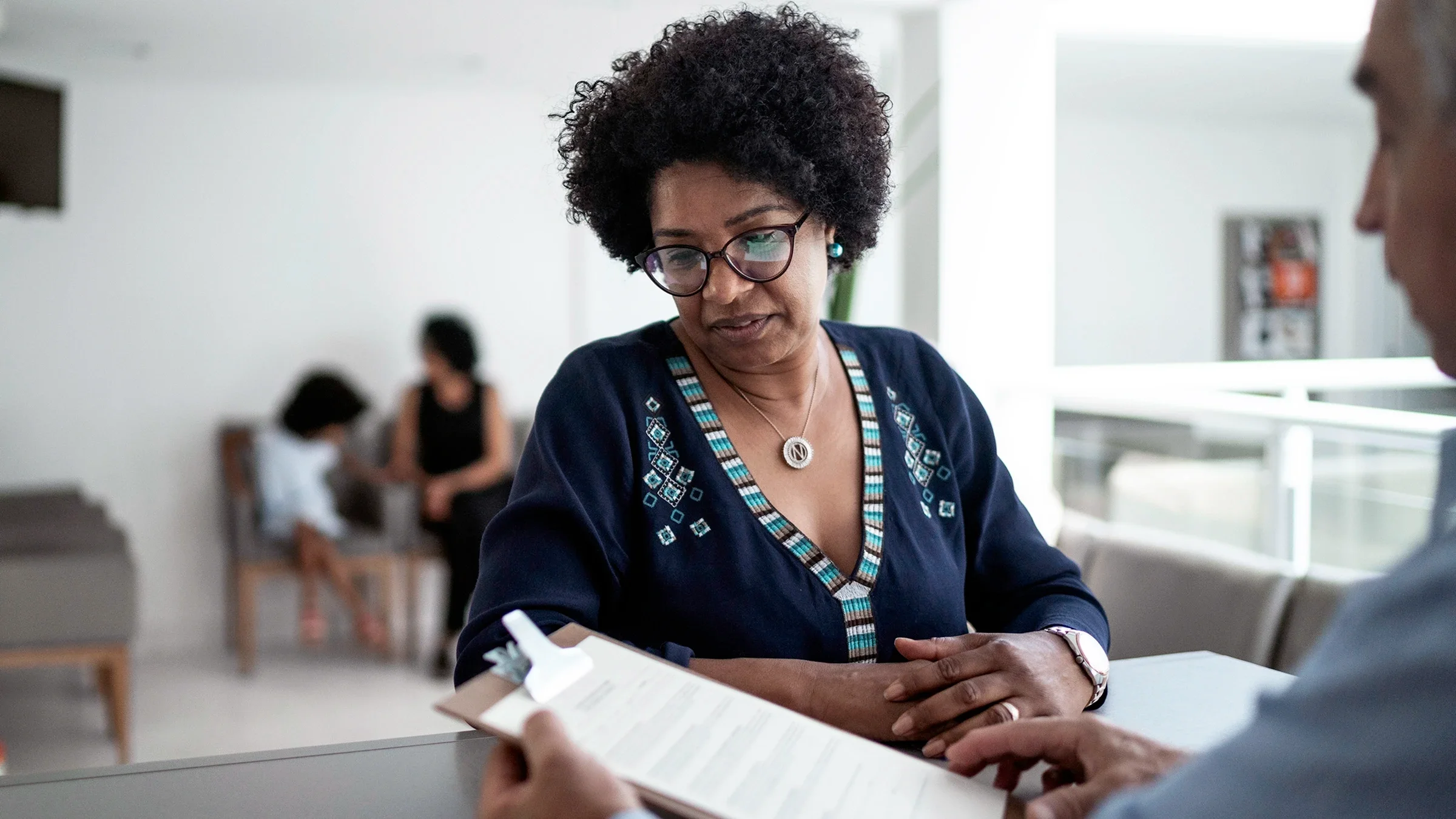A patient talks to hospital reception.
