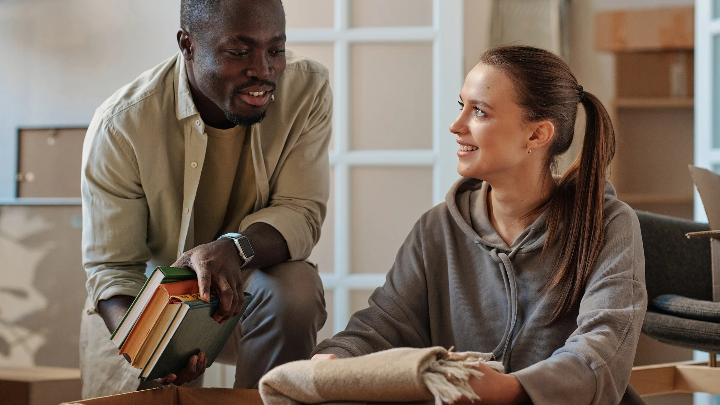 Couple packing items into a donation box.