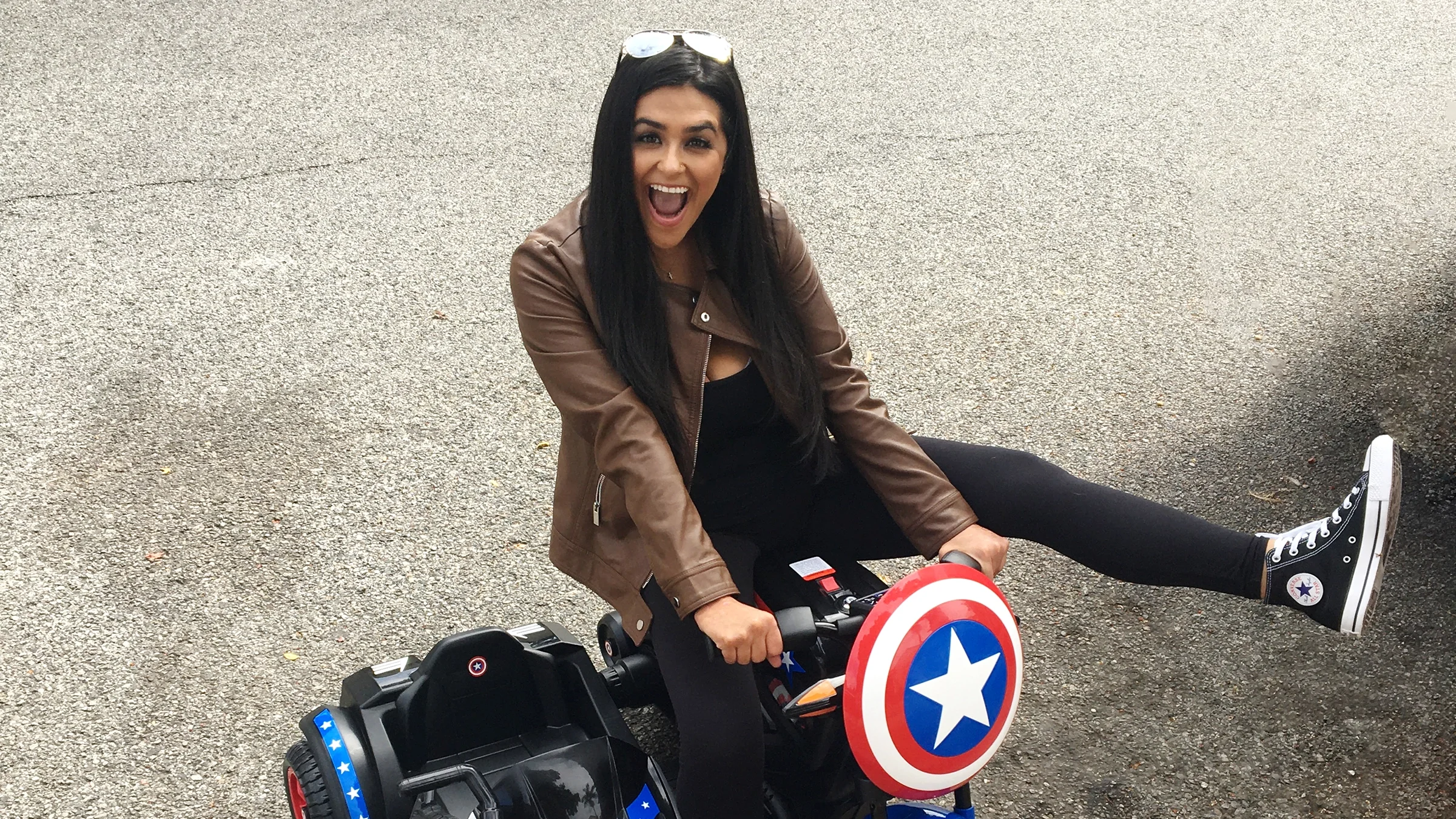 Image of Aimee Perez riding a toy car.