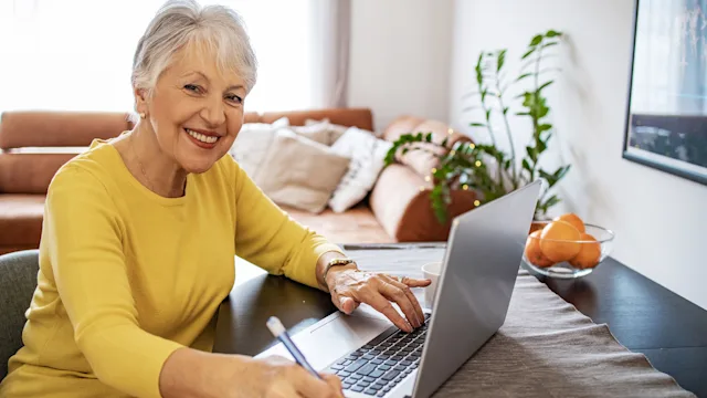 Health: Medicare: senior woman smiling laptop 1304788459