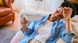 A woman fans herself on a sofa while experiencing a hot flash.
monkeybusinessimages/iStock via Getty Images Plus