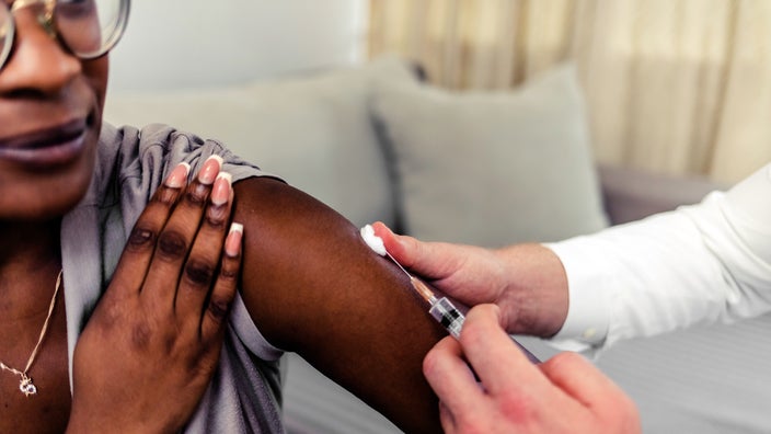 Close-up of woman receiving vaccine shot.