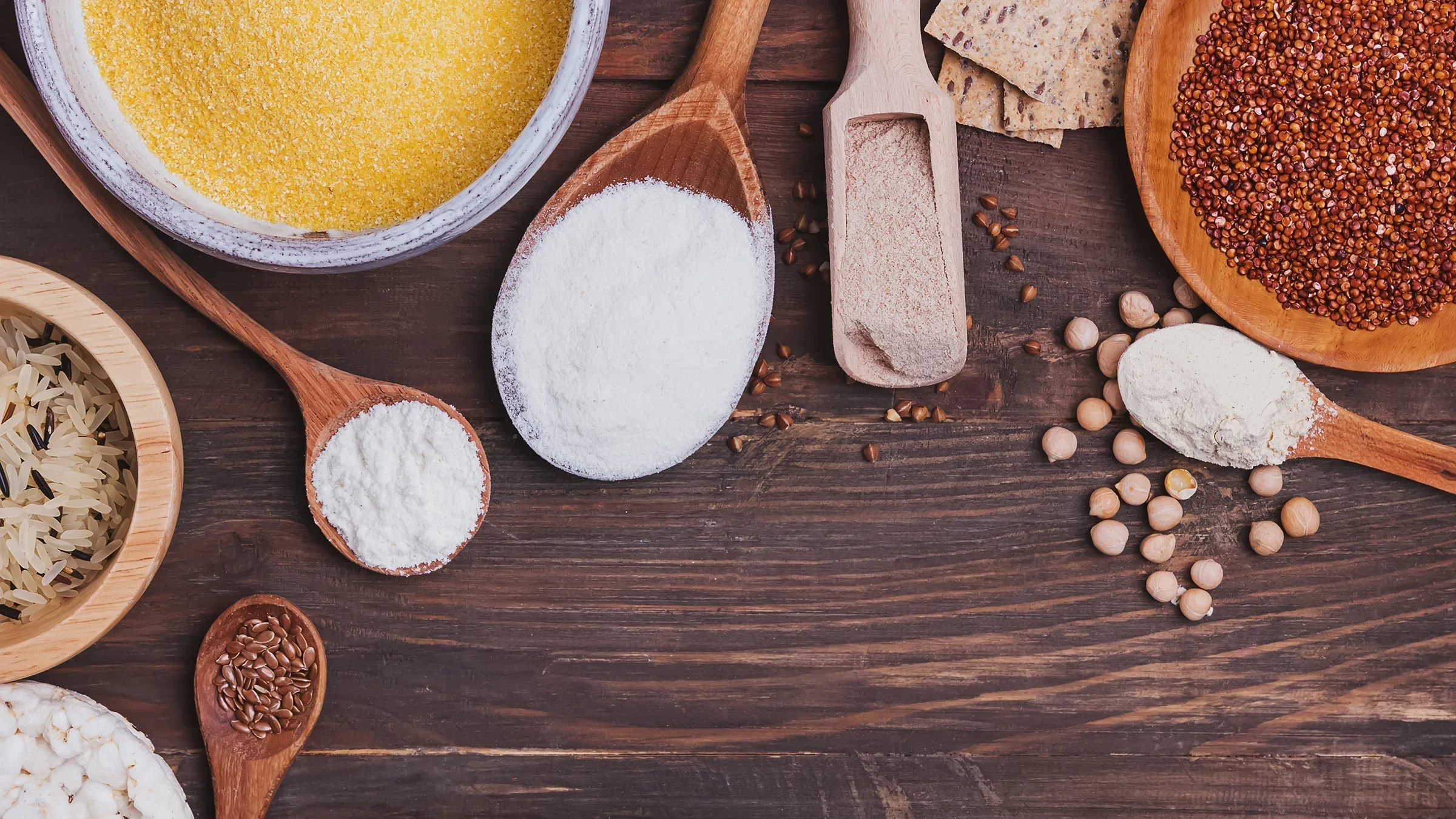 An image displays a variety of gluten-free flours in different bowls and spoons on a wooden background.
Chiociolla/iStock via Getty Images
