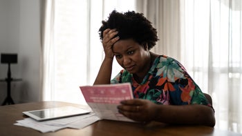 Personal Finance: woman reading a medical bill 1281077988