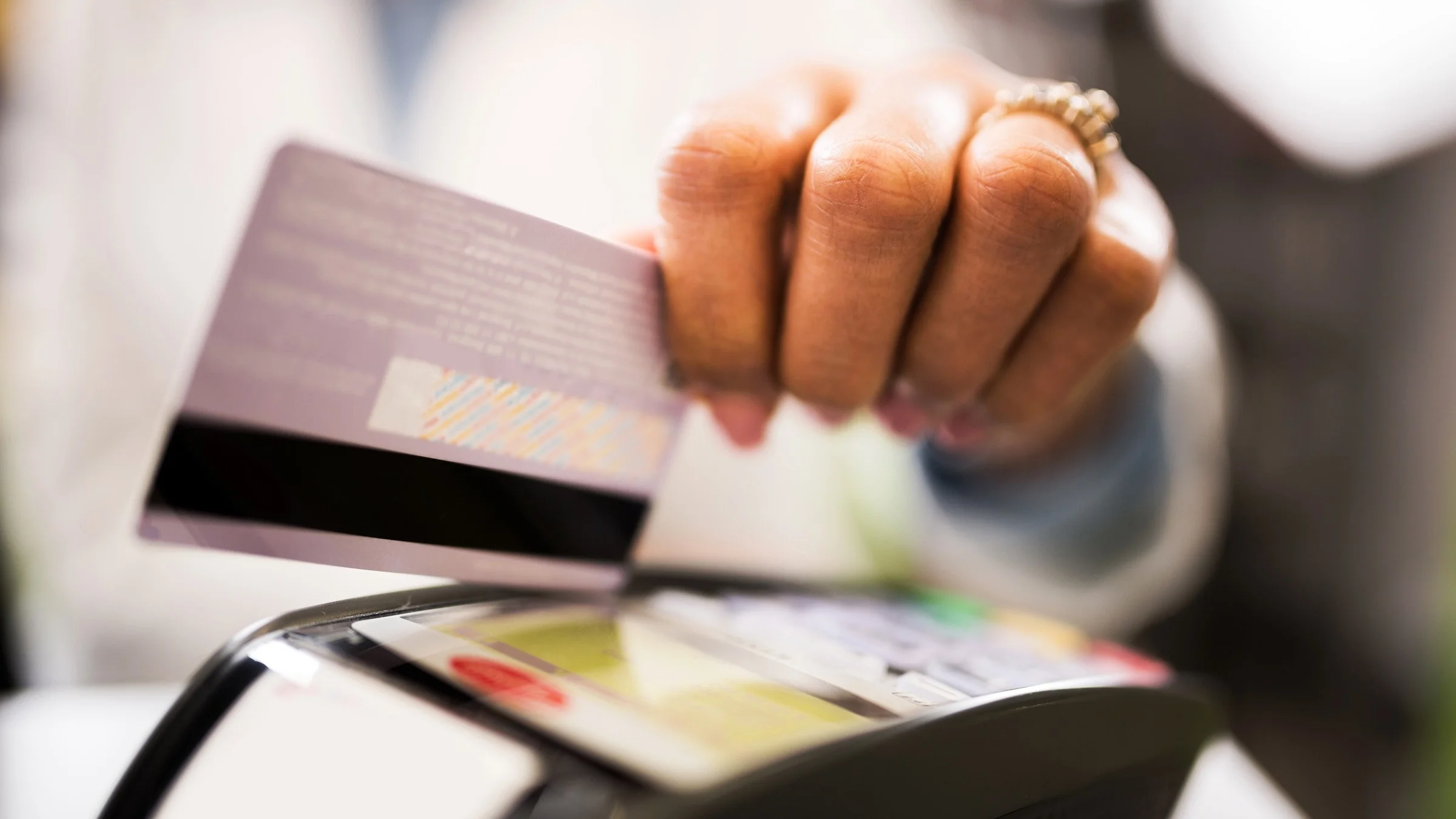 Black and white close-up of a person using their credit card to pay.