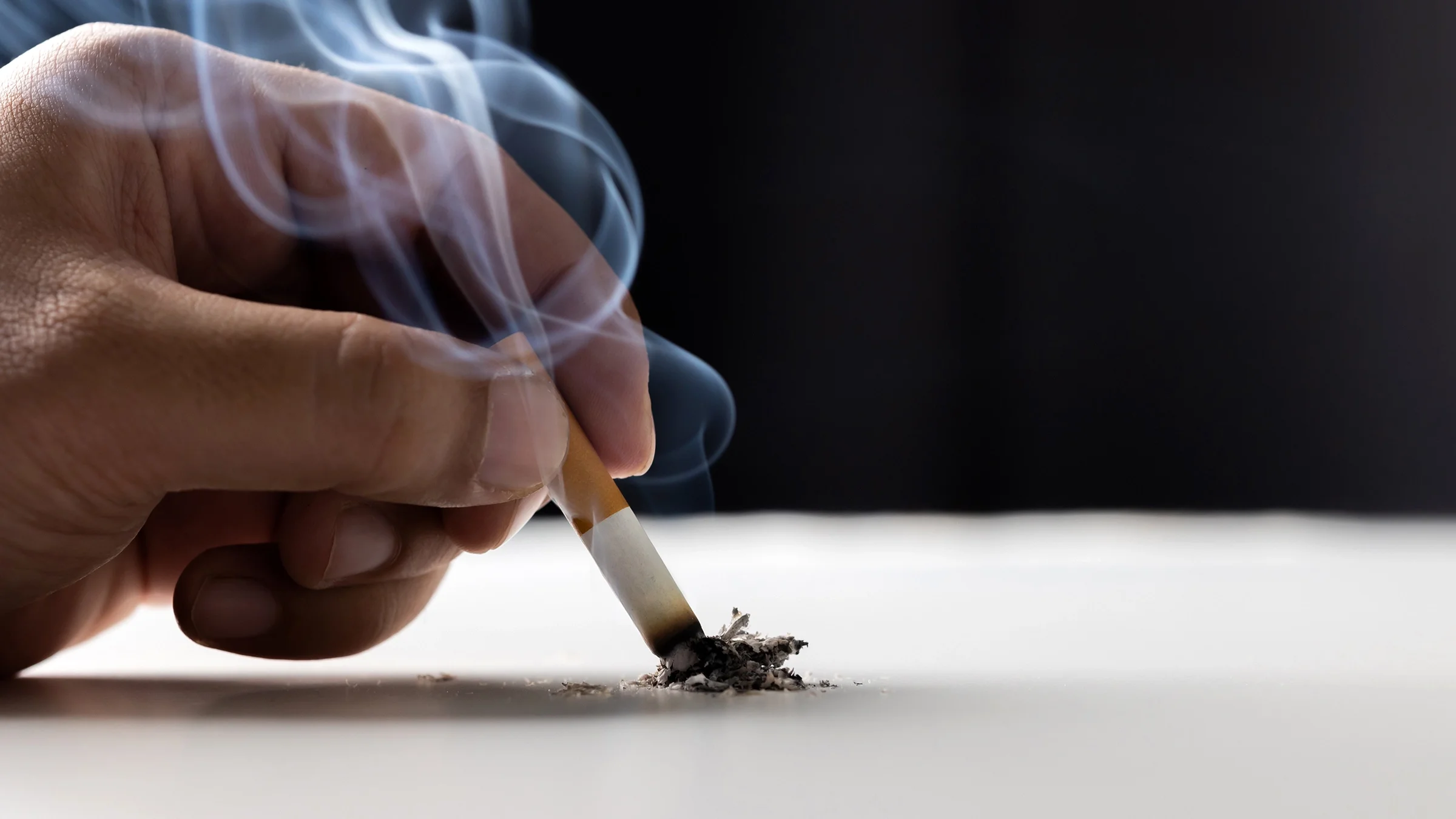 Someone is putting out a cigarette in a close-up.