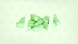 Light green background with halftone texture and warning sign pattern. In the center is a pile of green pills cut into thirds.
GoodRx Health