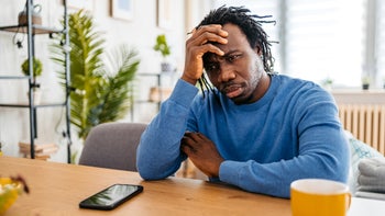 anxiety disorders: man sitting at table with worried expression 1477154505